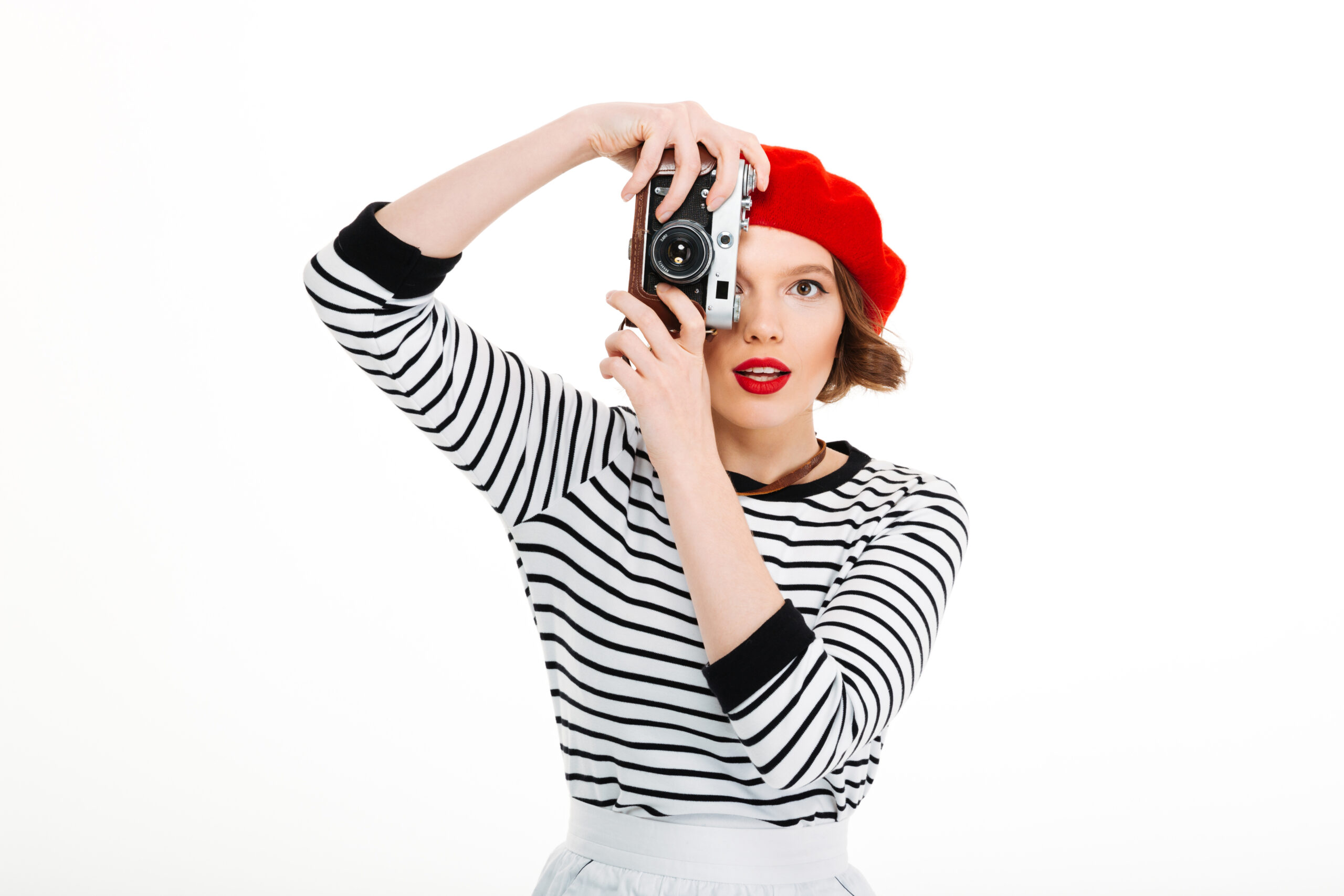 Image of young photographer woman isolated over white background wall holding camera.