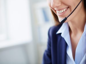 Toothy smile of young businesswoman with headset
