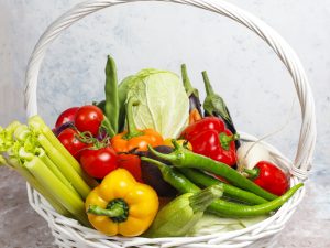 Different colorful fresh vegetables on light concrete background