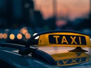 gros-plan-panneau-taxi-aux-couleurs-chaudes-du-coucher-du-soleil-lumieres-floues-arriere-plan